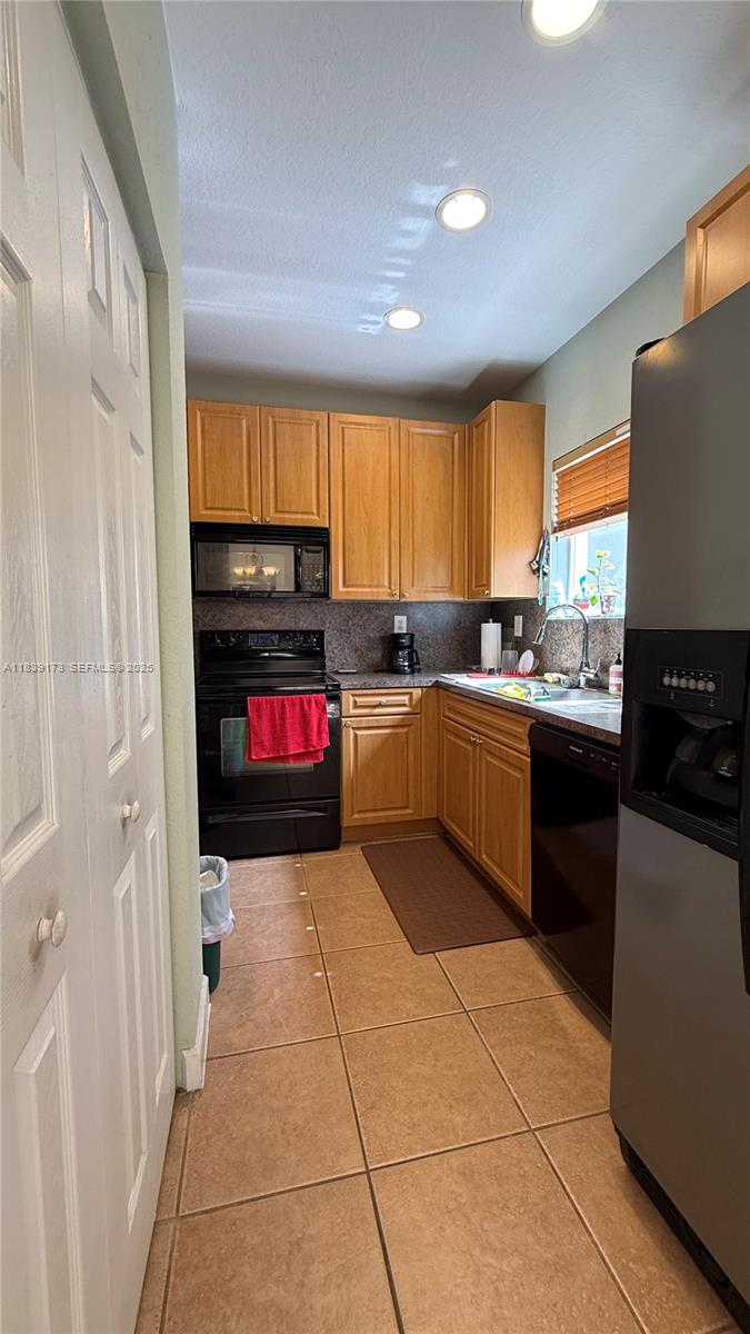 232 Southeast 32nd Terrace Homestead, FL 33033 - Photo 2 of 11 a kitchen with stainless steel appliances granite countertop a sink counter space cabinets and a window