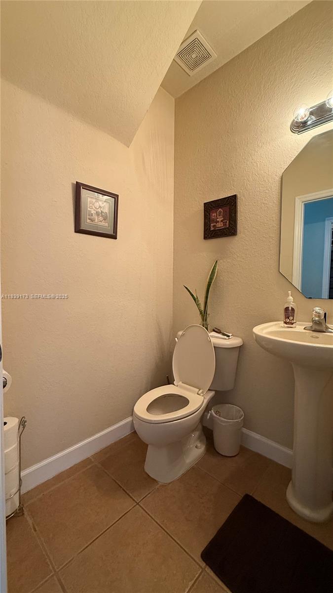 232 Southeast 32nd Terrace Homestead, FL 33033 - Photo 4 of 11 a bathroom with a toilet and a mirror