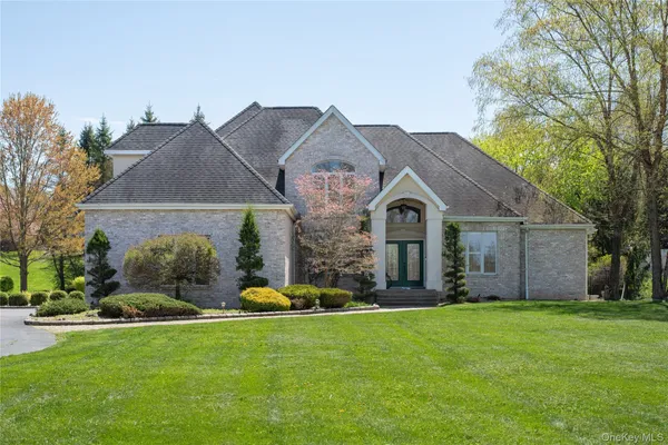 a front view of a house with a garden and plants