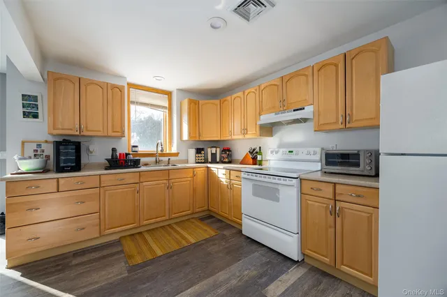 a kitchen with granite countertop white cabinets and white appliances