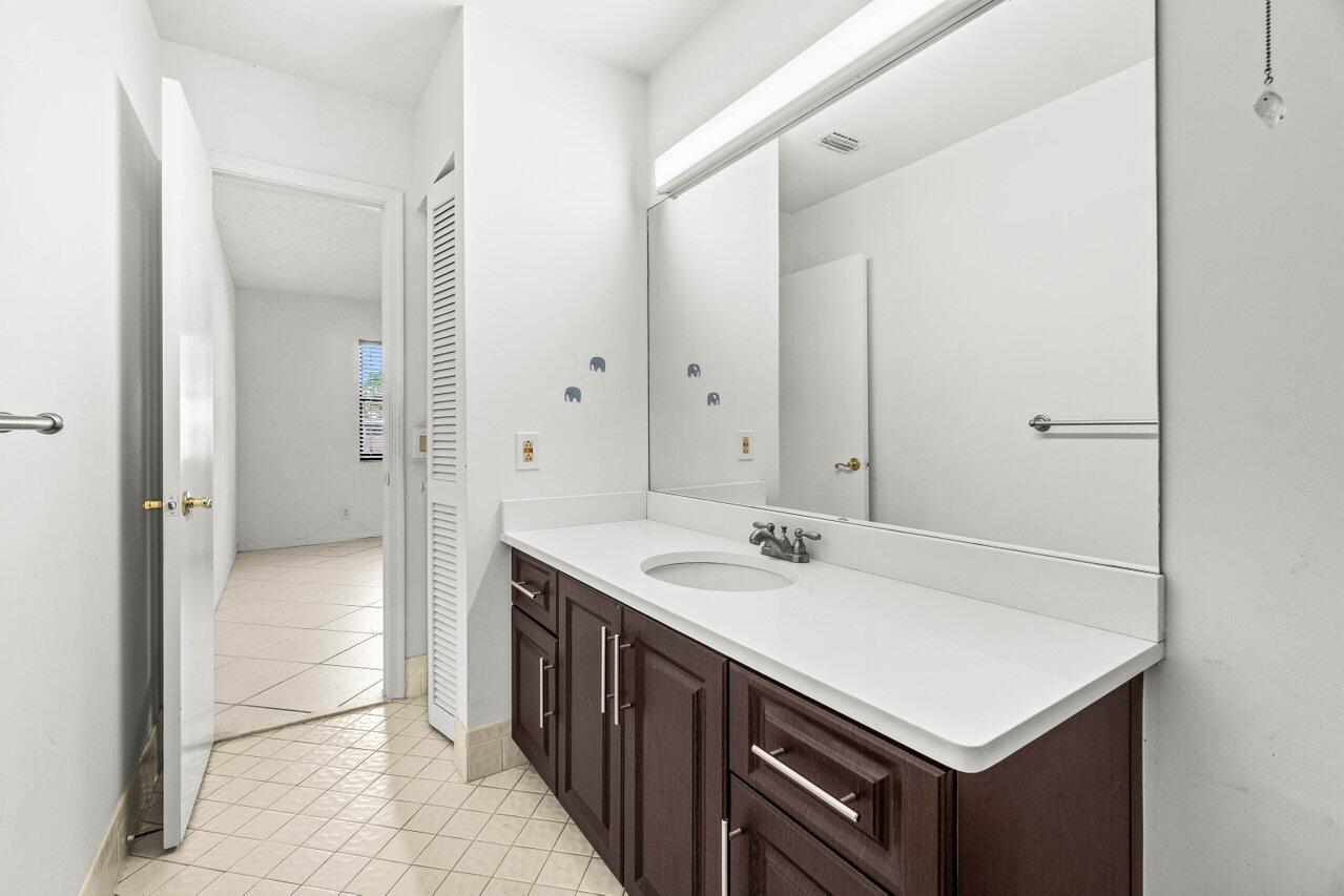 9308 Ketay Circle Boca Raton, FL 33428 - Photo 19 of 35 a bathroom with a sink a mirror and a shower