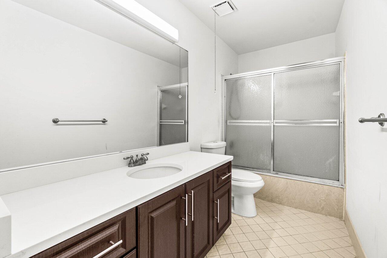 9308 Ketay Circle Boca Raton, FL 33428 - Photo 20 of 35 a bathroom with a sink a toilet a mirror and shower