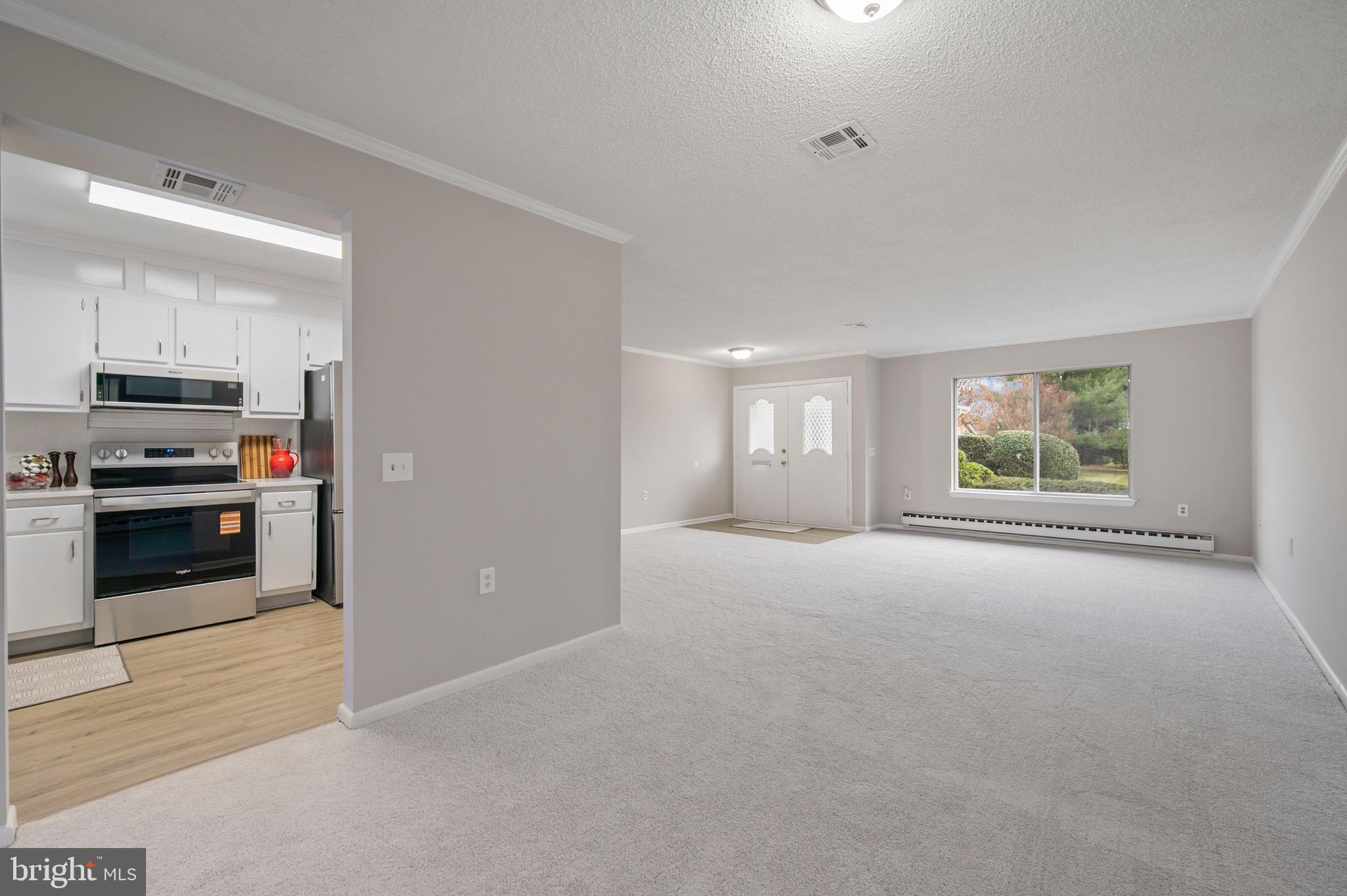 15561 Prince Frederick Way, Unit 114A Silver Spring, MD 20906 - Photo 13 of 32 a view of an empty room with a window and kitchen view