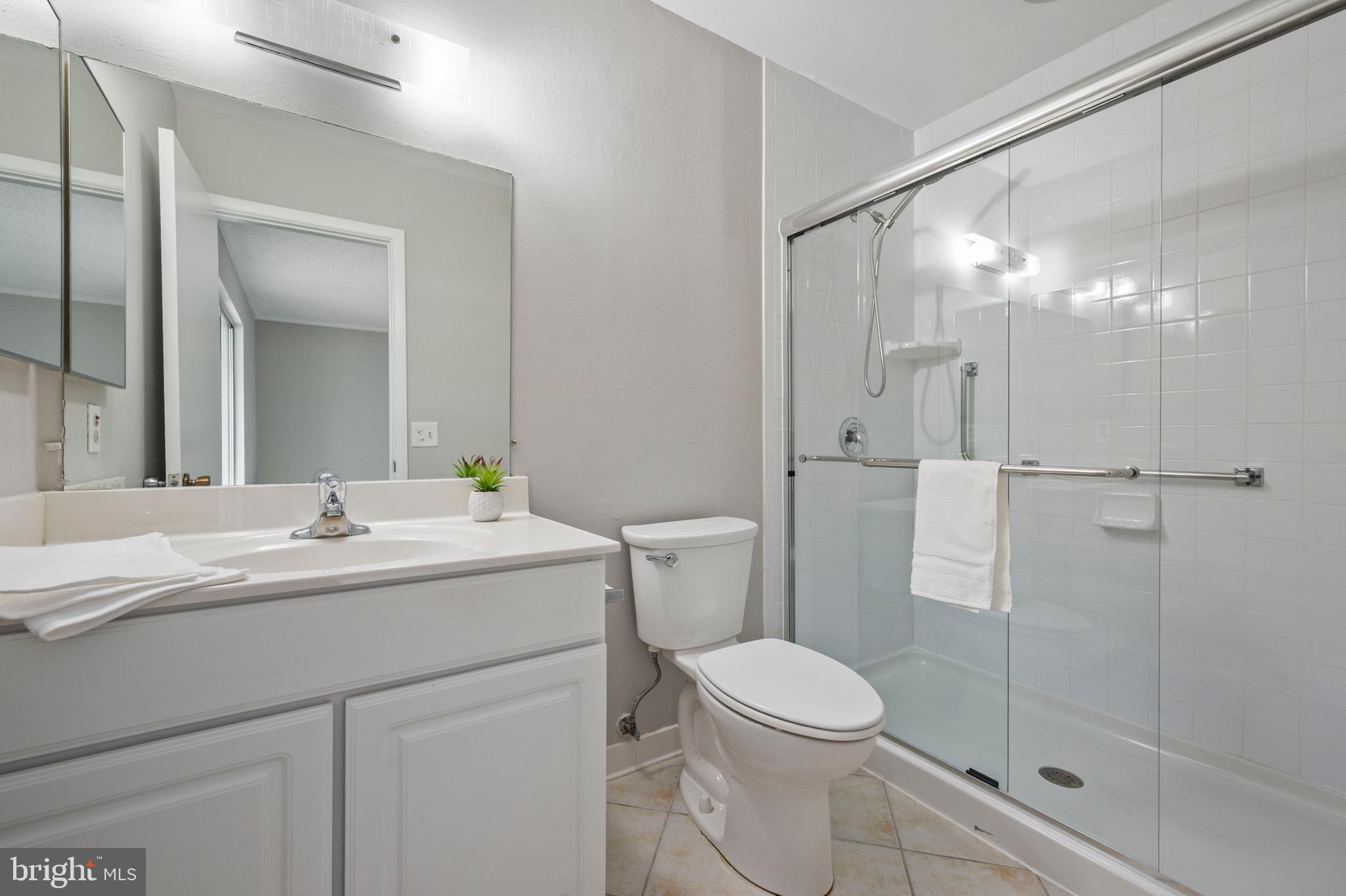 15561 Prince Frederick Way, Unit 114A Silver Spring, MD 20906 - Photo 22 of 32 a bathroom with a sink a toilet and shower