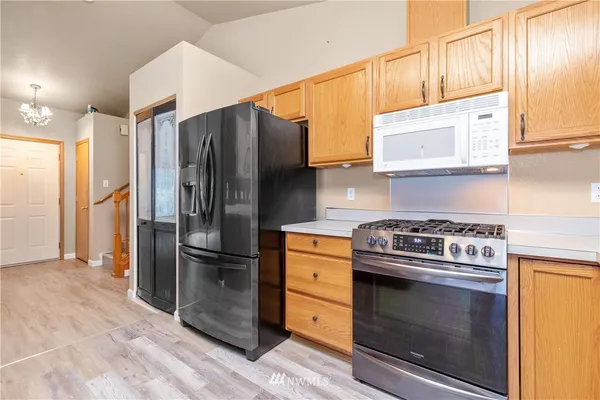 a kitchen with stainless steel appliances granite countertop a stove a refrigerator and a cabinets