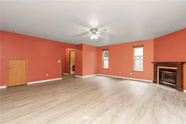 an empty room with windows and a fireplace