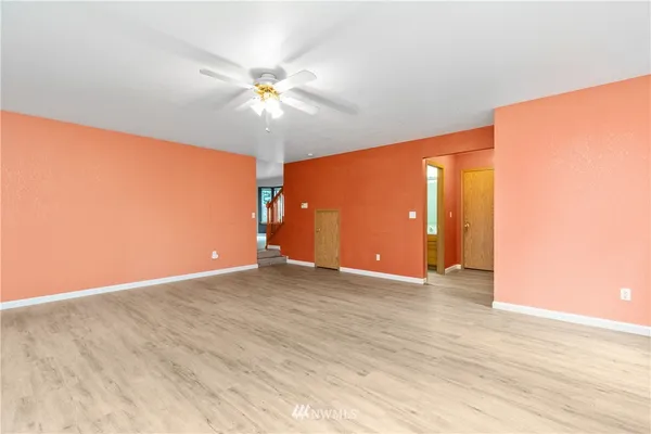 a view of an empty room with window and wooden floor