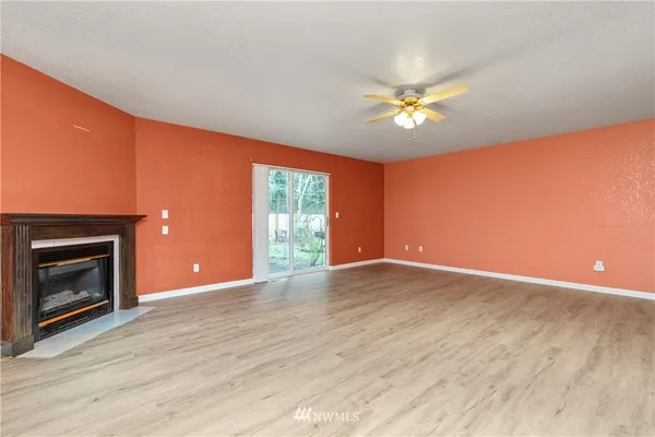 a view of empty room with a fireplace and wooden floor