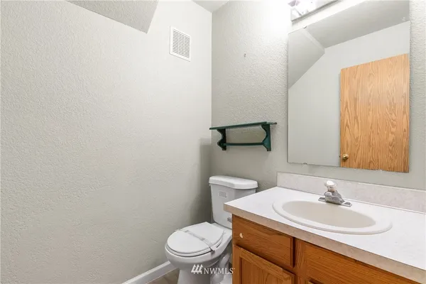 a bathroom with a sink a toilet and mirror