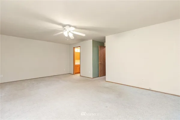 an empty room with a ceiling fan and a window