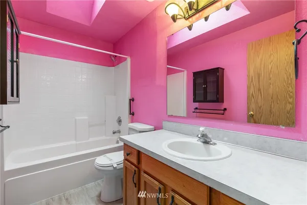 a bathroom with a granite countertop sink a toilet and shower
