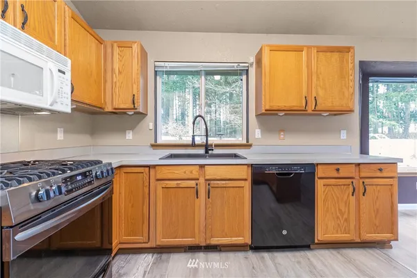 a kitchen with stainless steel appliances granite countertop a stove a sink and a microwave