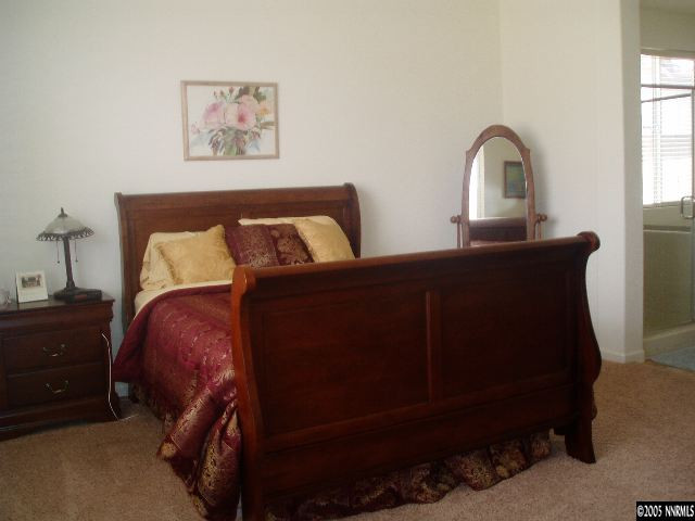 10645 Copper Lake Drive Reno, NV 89521 - Photo 5 of 8 a bed sitting in a bedroom next to a window with a dresser