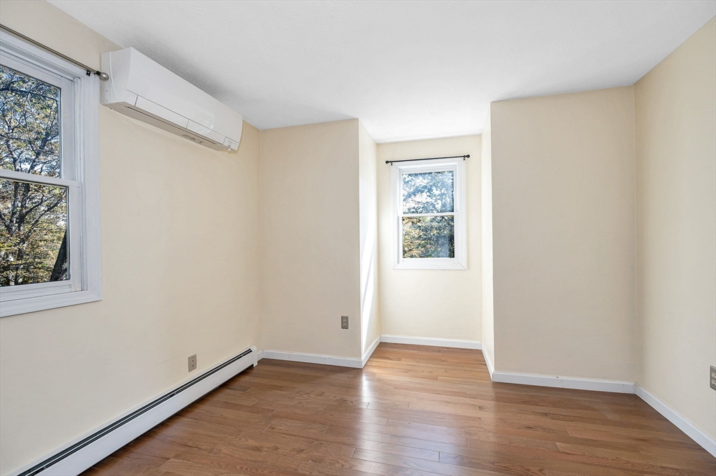 38 Pine Ridge Drive Ayer, MA 01432 - Photo 16 of 42 an empty room with wooden floor and windows