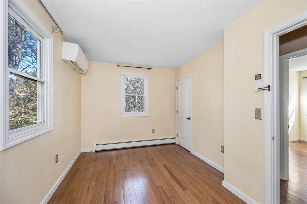38 Pine Ridge Drive Ayer, MA 01432 - Photo 19 of 42 an empty room with wooden floor and windows