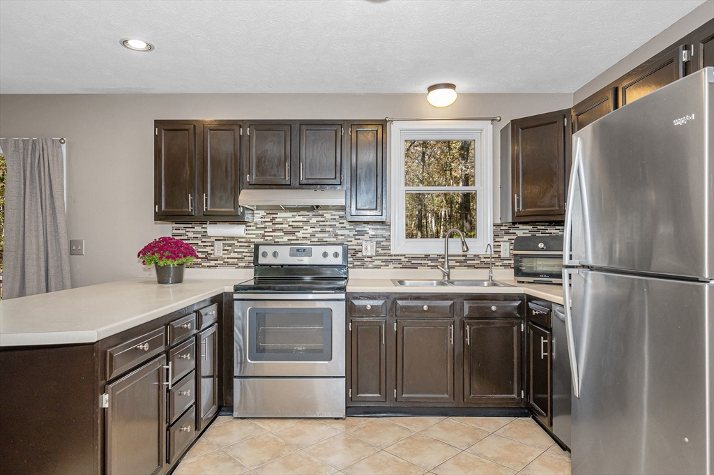 38 Pine Ridge Drive Ayer, MA 01432 - Photo 4 of 42 a kitchen with stainless steel appliances granite countertop a sink stove and refrigerator