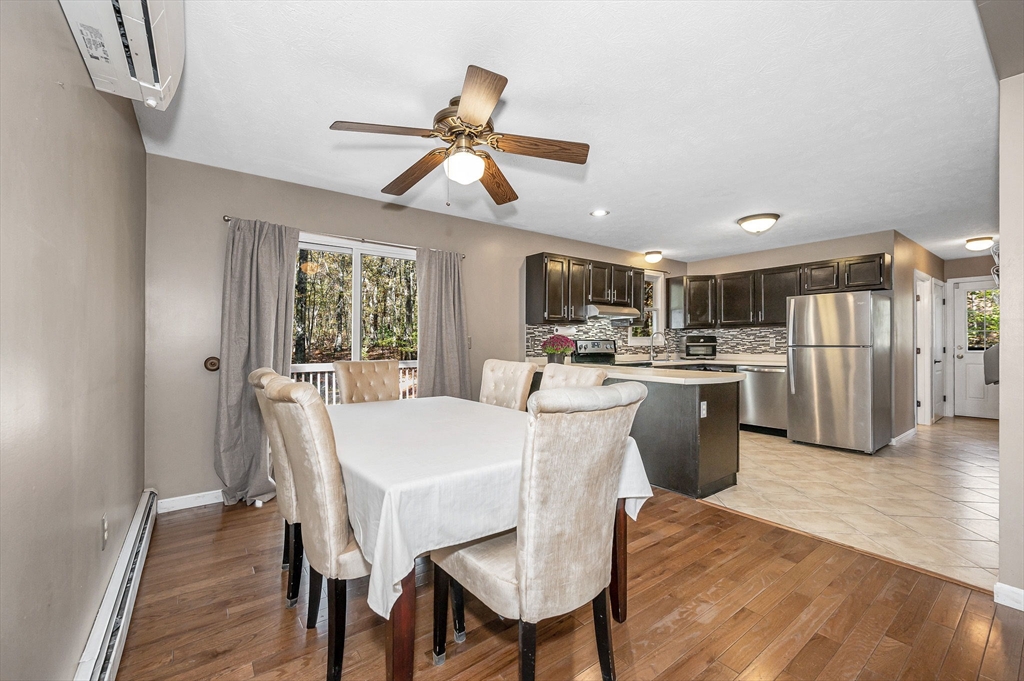 38 Pine Ridge Drive Ayer, MA 01432 - Photo 7 of 42 a dining room with stainless steel appliances kitchen island granite countertop a refrigerator a stove a sink dishwasher and a dining table with wooden floor