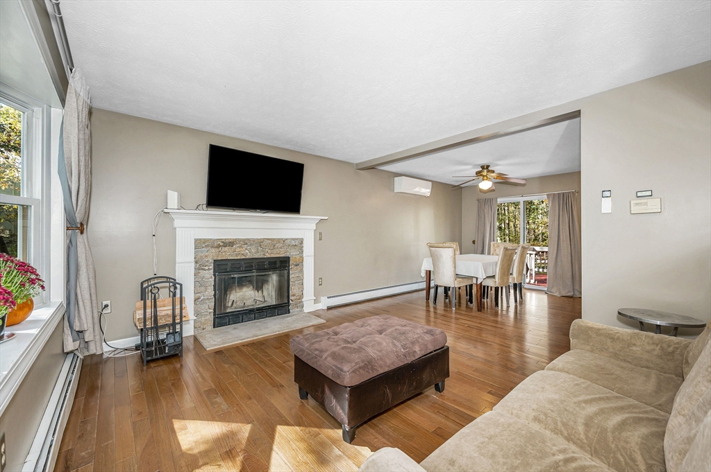 38 Pine Ridge Drive Ayer, MA 01432 - Photo 9 of 42 a living room with furniture a flat screen tv and a fireplace