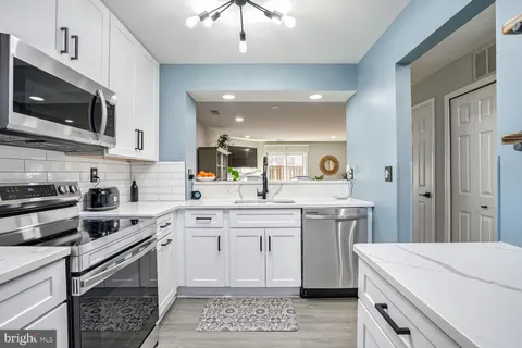 a kitchen with a sink a stove and cabinets