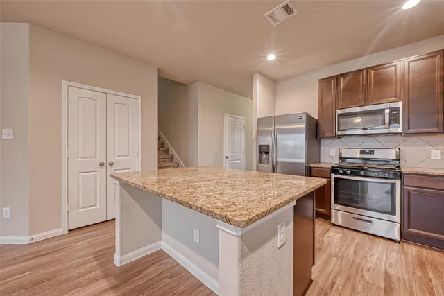 a kitchen with stainless steel appliances granite countertop a sink stove and microwave