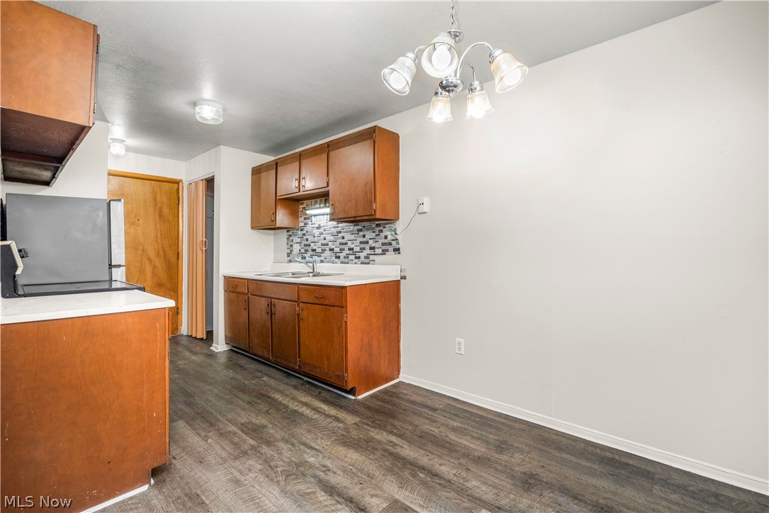 5370 Lee Road, Unit 302 Maple Heights, OH 44137 - Photo 13 of 29 Kitchen featuring light countertops, decorative backsplash, wood finish cabinets, dark wood-style floors, and freestanding refrigerator