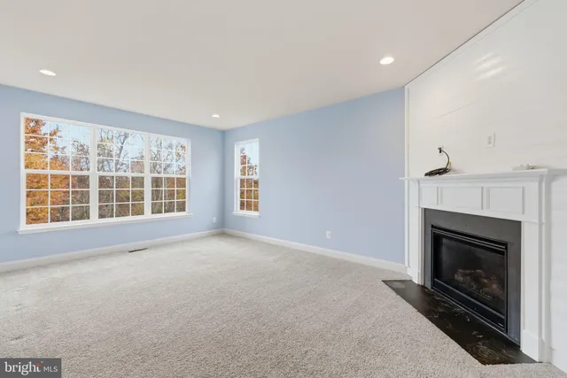 a view of an empty room with a fireplace and cabinet