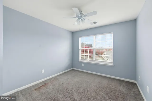 a view of a livingroom with a ceiling fan and window