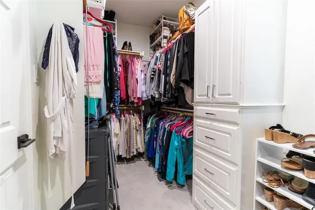 a view of walk in closet with clothes