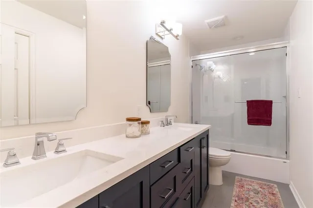 a bathroom with a sink vanity granite toilet tub and shower