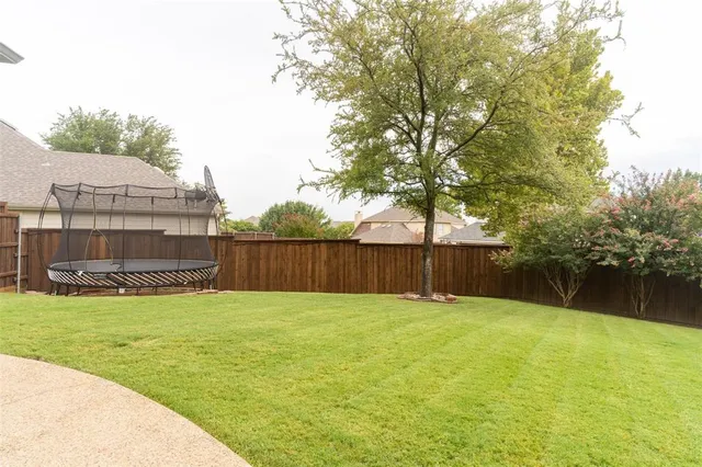 a view of a swimming pool with a big yard and large tree