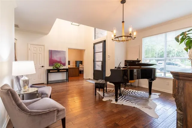 a dining room with furniture a chandelier and wooden floor