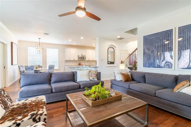 a living room with furniture kitchen view and a chandelier