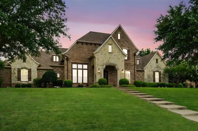 a front view of a house with a yard and trees