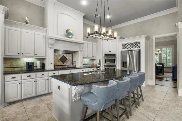 a kitchen with kitchen island granite countertop a sink a center island and cabinets