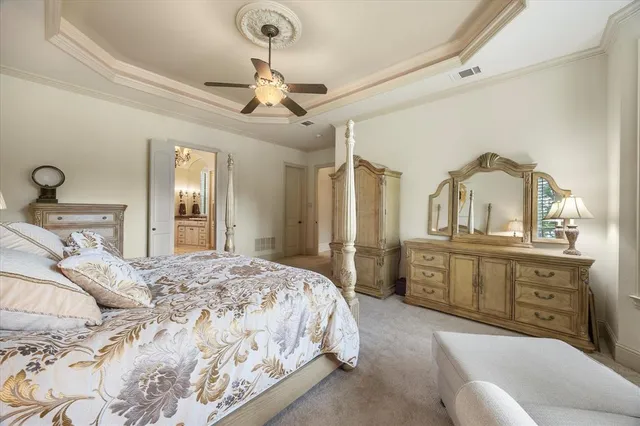 a bedroom with a large bed and ceiling fan