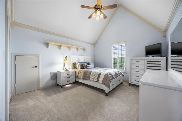 a spacious bedroom with a bed and a flat tv screen