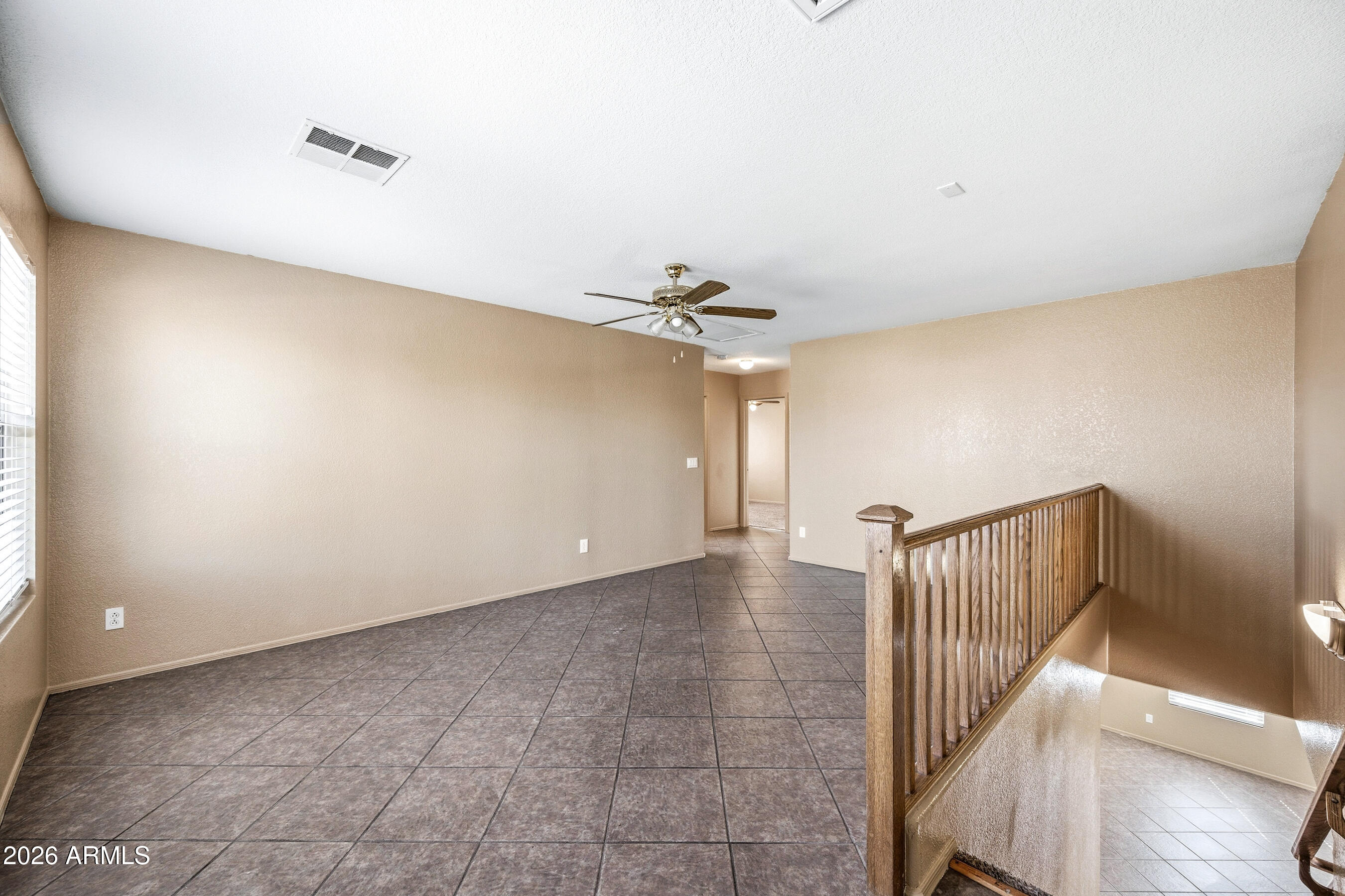 9515 West Monte Vista Road Phoenix, AZ 85037 - Photo 14 of 29 a view of a hallway with a ceiling fan and stairs