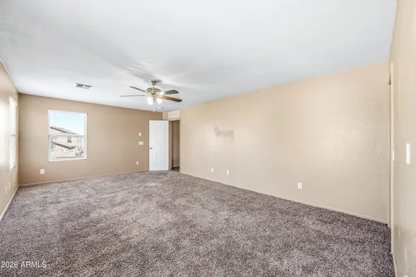 a view of a big room with windows and chandelier fan