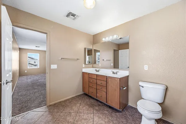 a bathroom with a sink vanity mirror and toilet