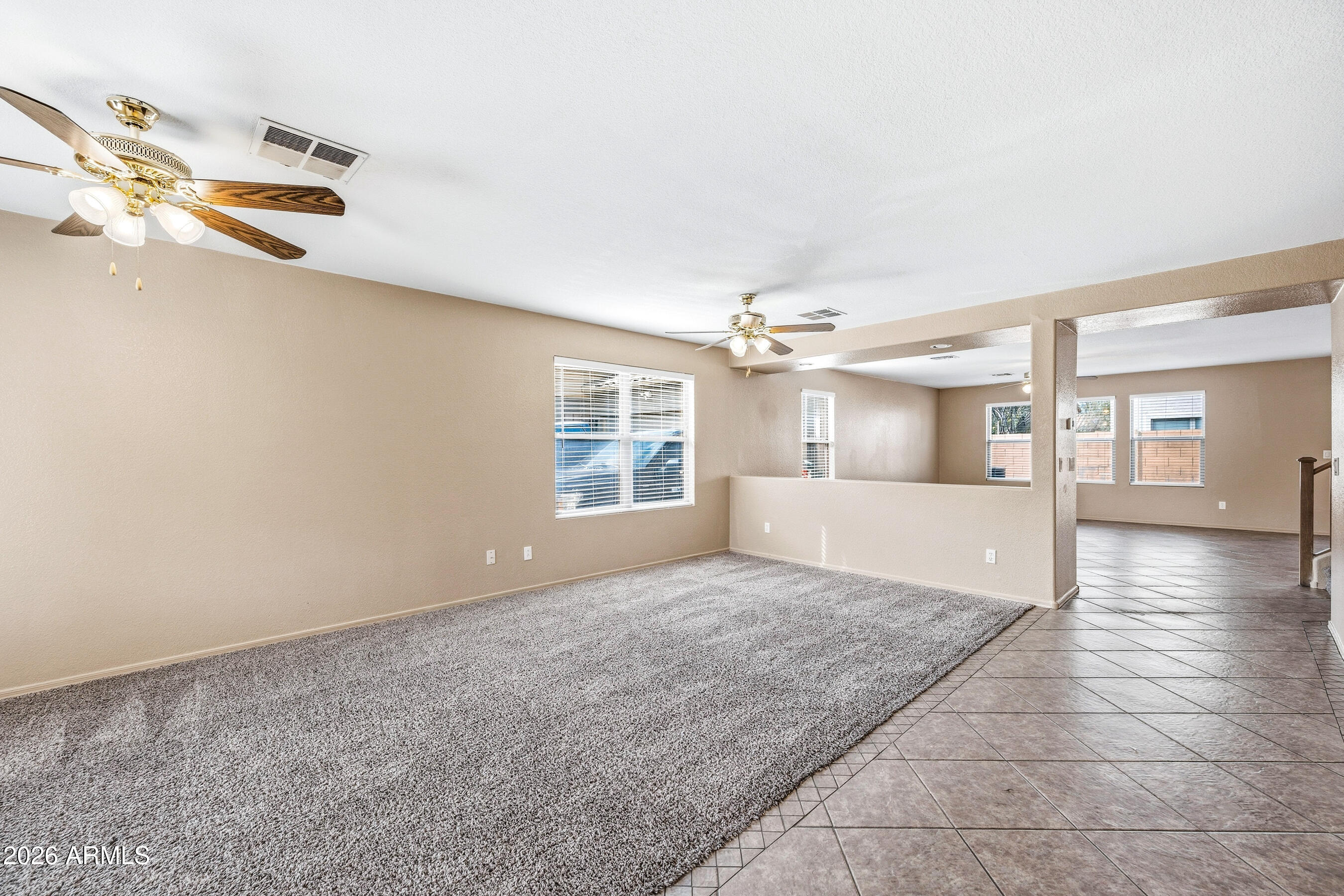 9515 West Monte Vista Road Phoenix, AZ 85037 - Photo 2 of 29 an empty room with windows and chandelier fan