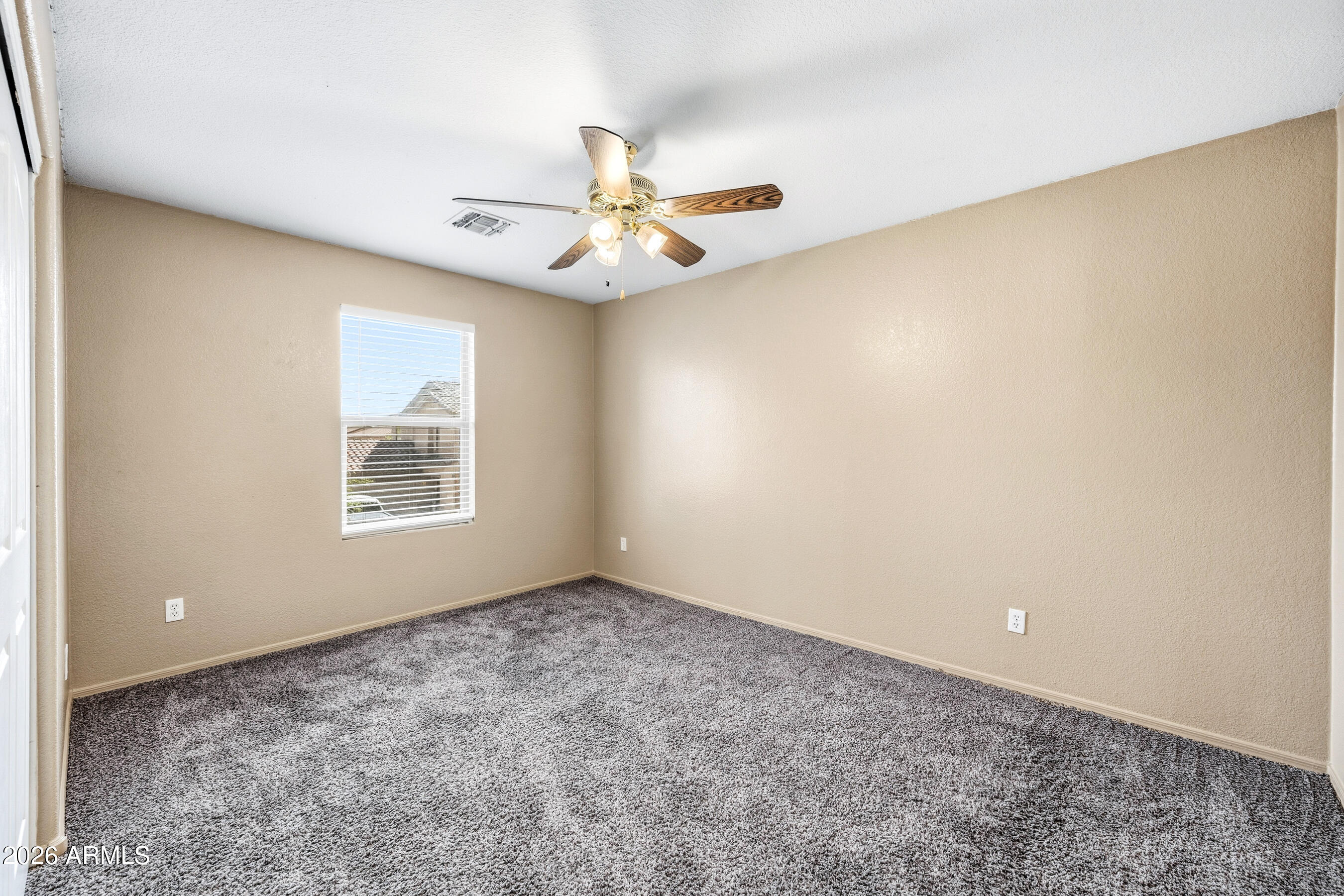 9515 West Monte Vista Road Phoenix, AZ 85037 - Photo 24 of 29 an empty room with windows and ceiling fan