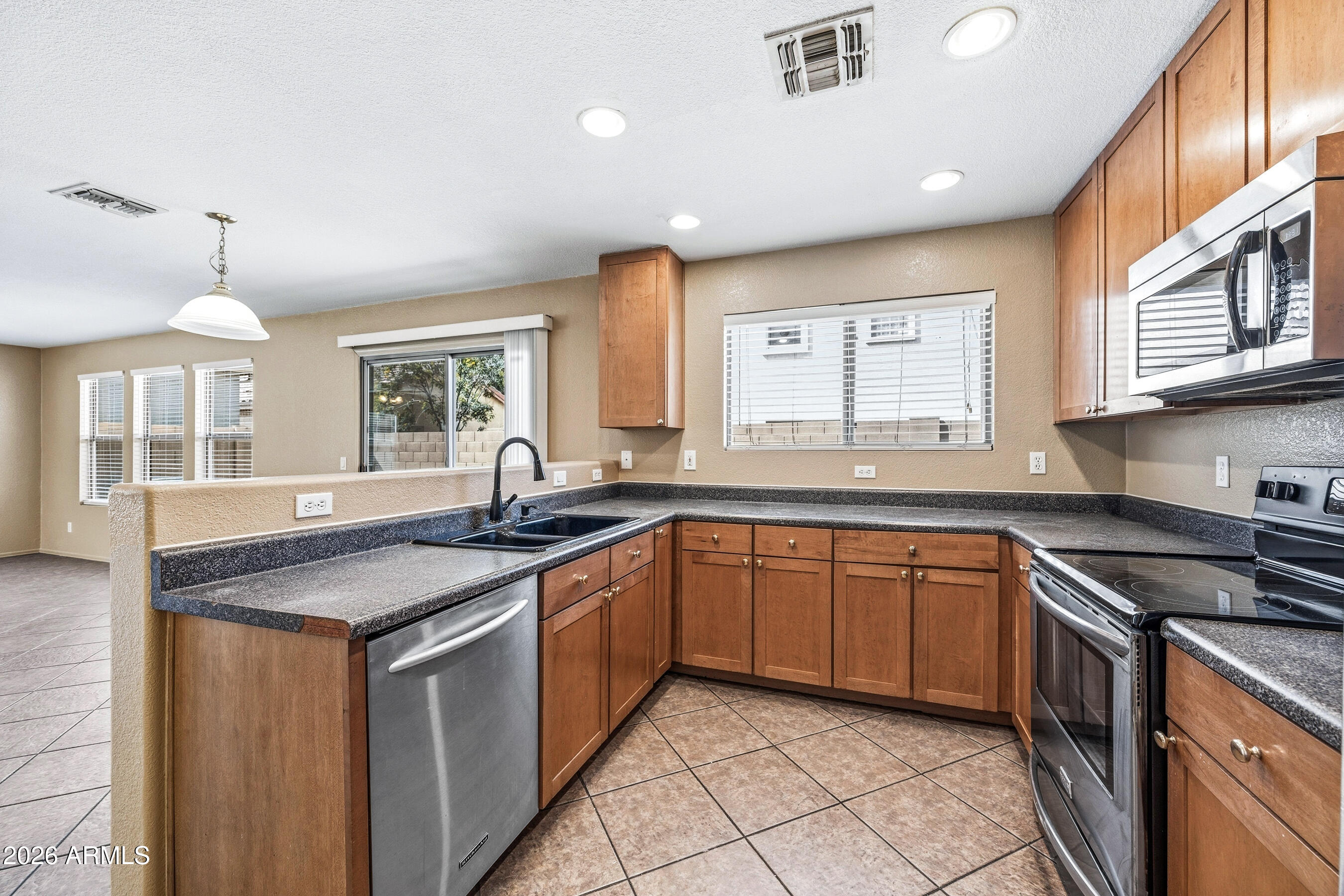 9515 West Monte Vista Road Phoenix, AZ 85037 - Photo 10 of 29 a kitchen with granite countertop a sink stove and cabinets