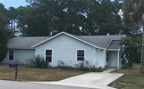 a front view of house with yard and trees around
