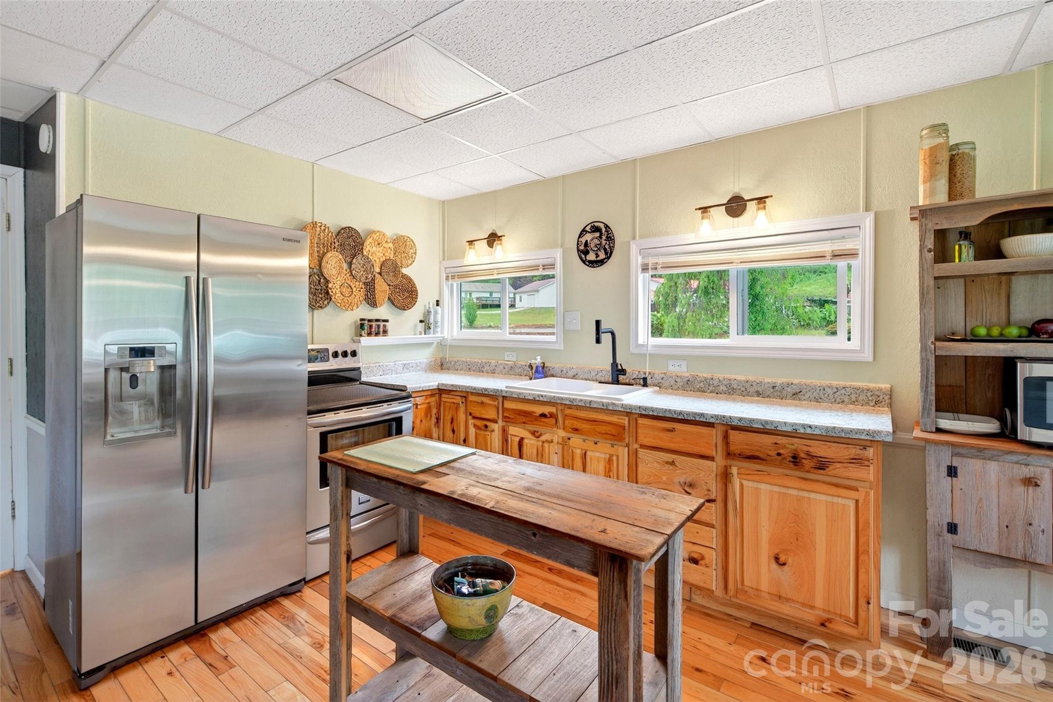 227 Locust Cove Road Marion, NC 28752 - Photo 8 of 34 a kitchen with stainless steel appliances granite countertop a refrigerator a stove and a sink with large window