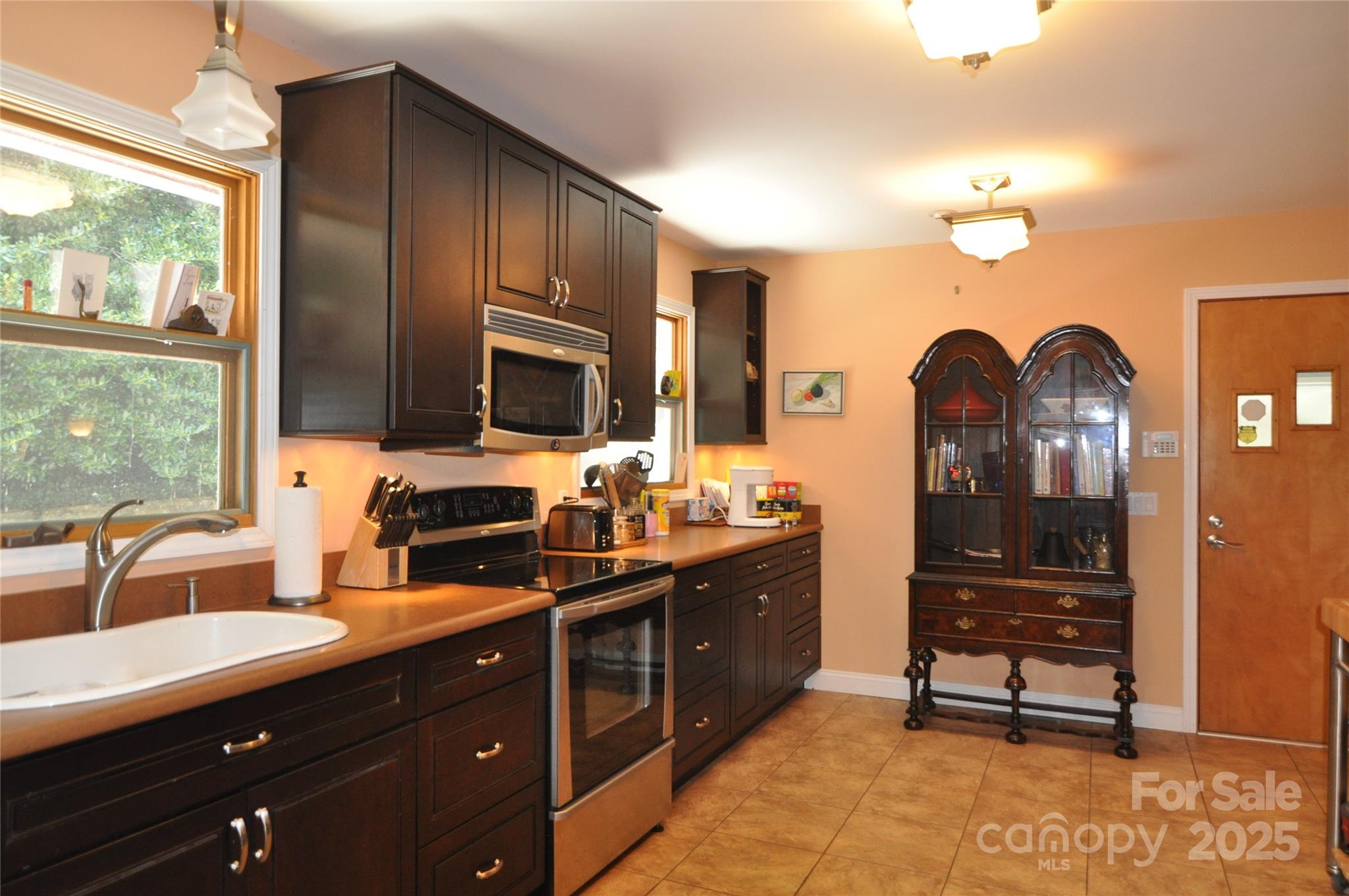502 Meadowlark Drive Tryon, NC 28782 - Photo 21 of 40 a kitchen with granite countertop a stove a sink dishwasher a dining table and chair with wooden floor