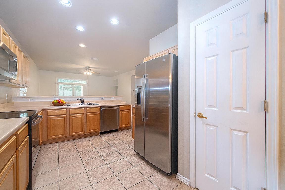 510 Crockett Loop Georgetown, TX 78633 - Photo 5 of 16 a kitchen with stainless steel appliances granite countertop a refrigerator and a sink