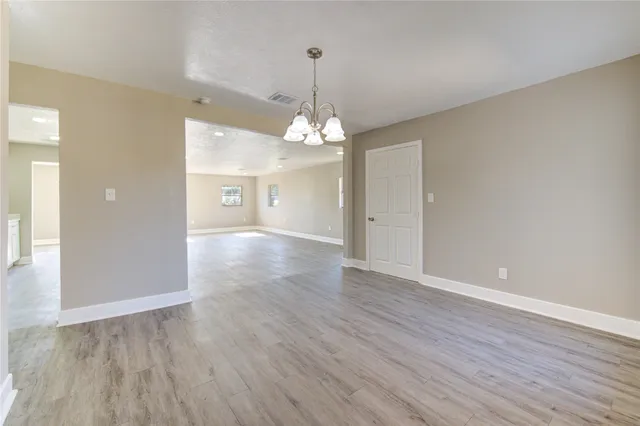 a view of a room with wooden floor and chandelier