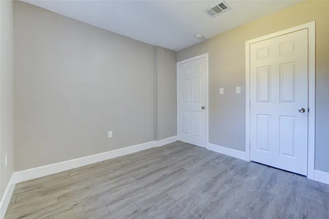 a view of an empty room with wooden floor