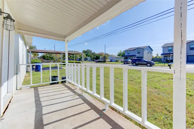a porch with a table and chairs