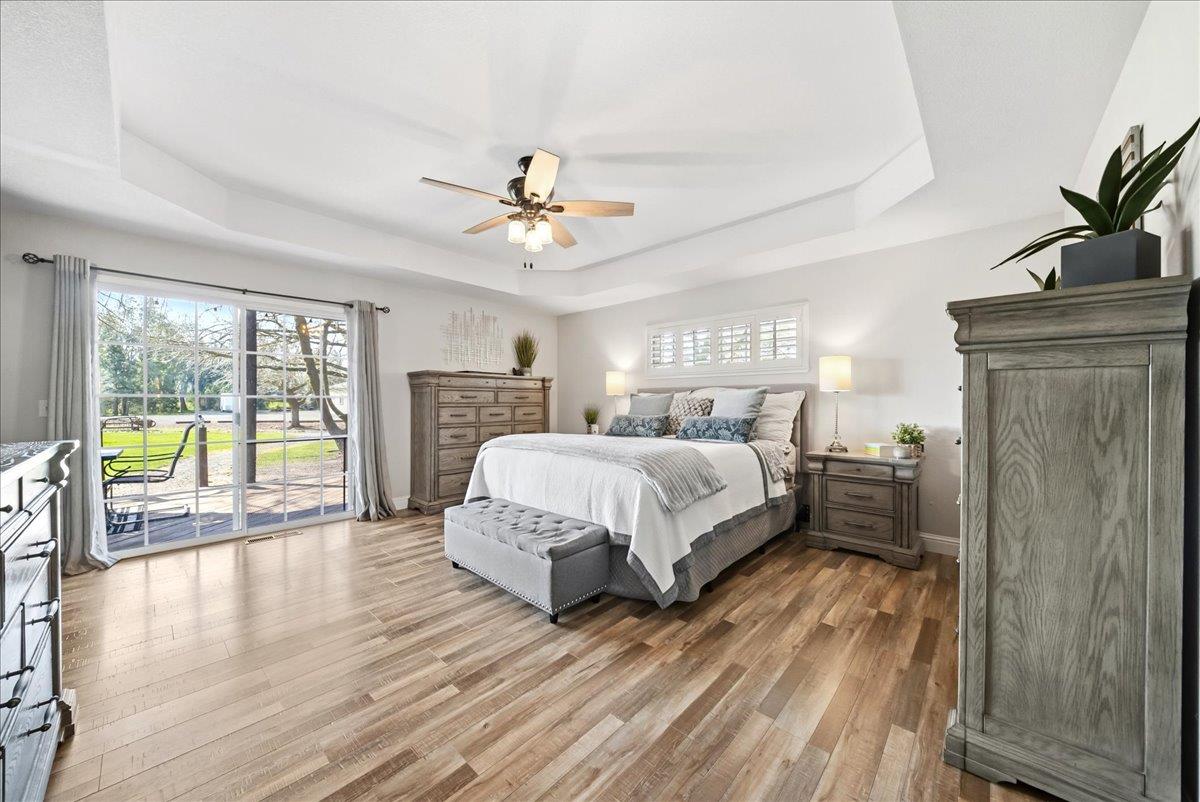 9777 Tavernor Road Wilton, CA 95693 - Photo 21 of 59 a spacious bedroom with a large bed a chandelier and windows